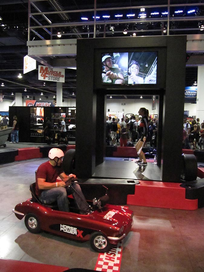 Canavan Scenic & Light provided some exciting AV Solutions for the Ultimate Nutrition booth at the Mr. Olympia Show in Las Vegas, the client wanted to hold adult pedal car races around a track located inside their booth. We outfitted the pedal cars with wireless cameras which relayed video of drivers faces in real time back to several 50” monitors in the center of the booth. For their race announcements and t-shirt giveaways CS&L also provided a club sized audio system and lighting rig, along with live dancers and smoke machines for full effect! 
